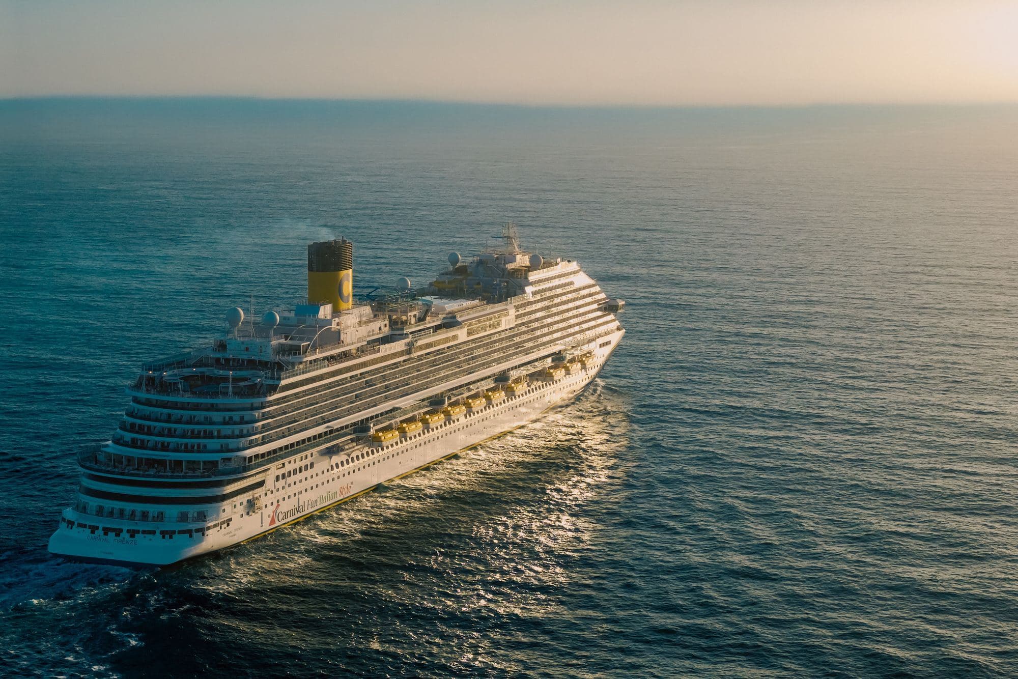 A cruise ship sailing on open water at golden hour